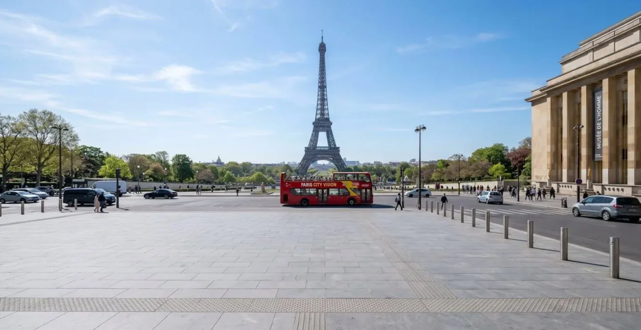 Vue grand angle de la place du Trocadéro avec un bus touristique rouge à impériale visible au second plan et la Tour Eiffel en arrière-plan sous lumière matinale