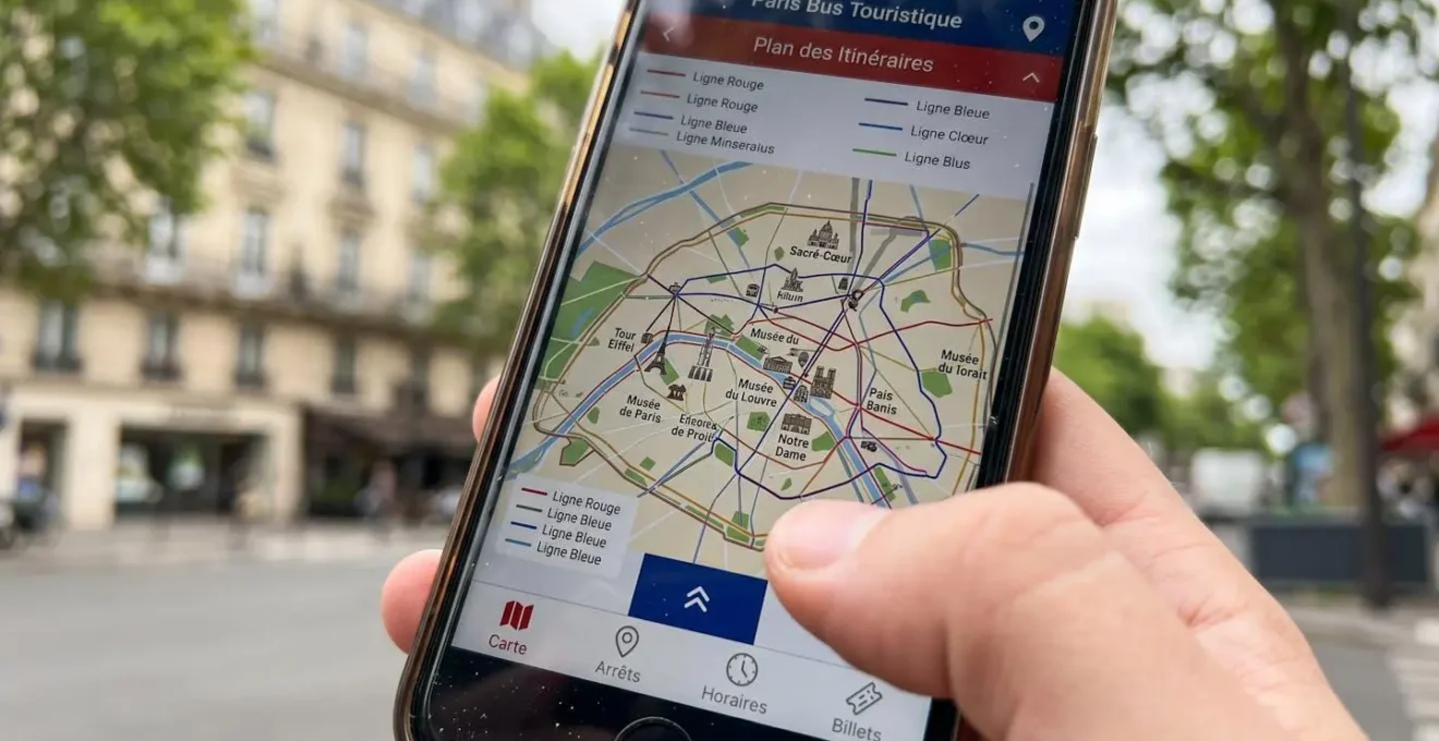 Gros plan sur un écran de smartphone affichant une application de bus touristique avec carte de Paris et monuments, architecture parisienne floue en arrière-plan